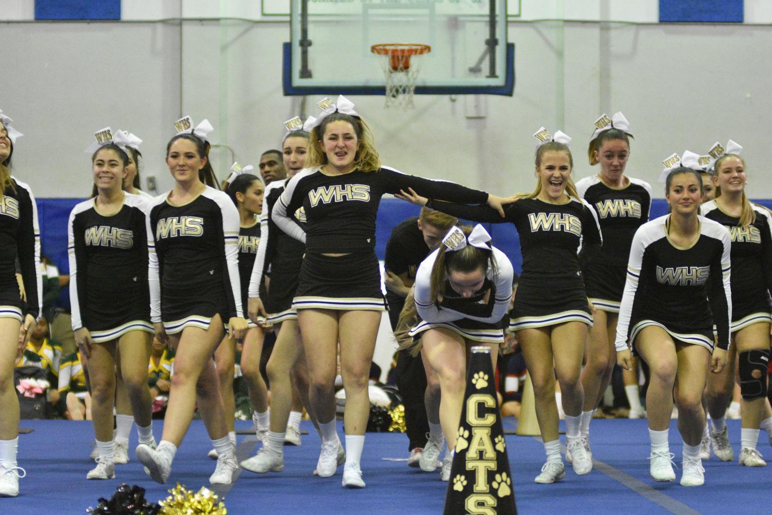 The cheerleading team preps for the opening jump sequence at the Jan. 26 regional competition at Coral Springs High School.