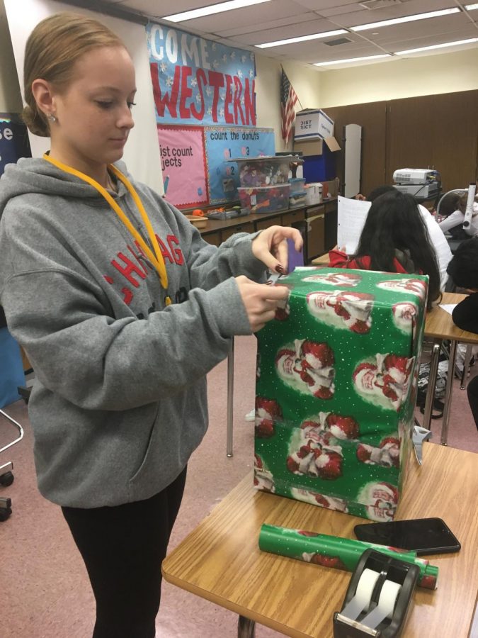 FEA president Emma Chandler wraps boxes for classrooms collecting for the toy drive.
