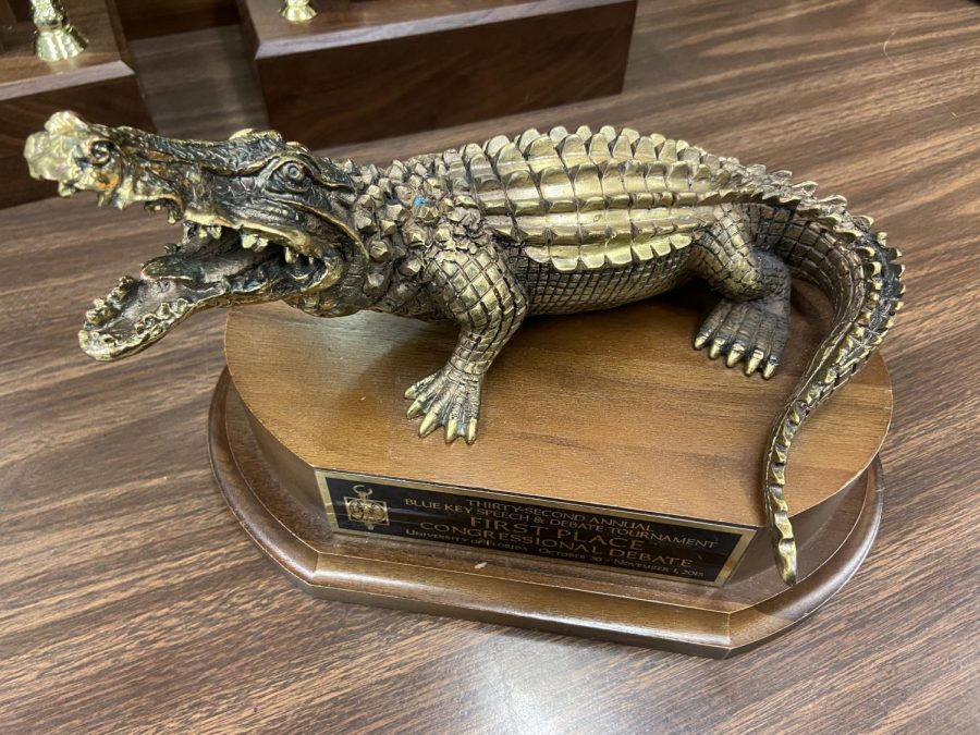 The Blue Key Gator award is displayed among other awards in the debate room. 