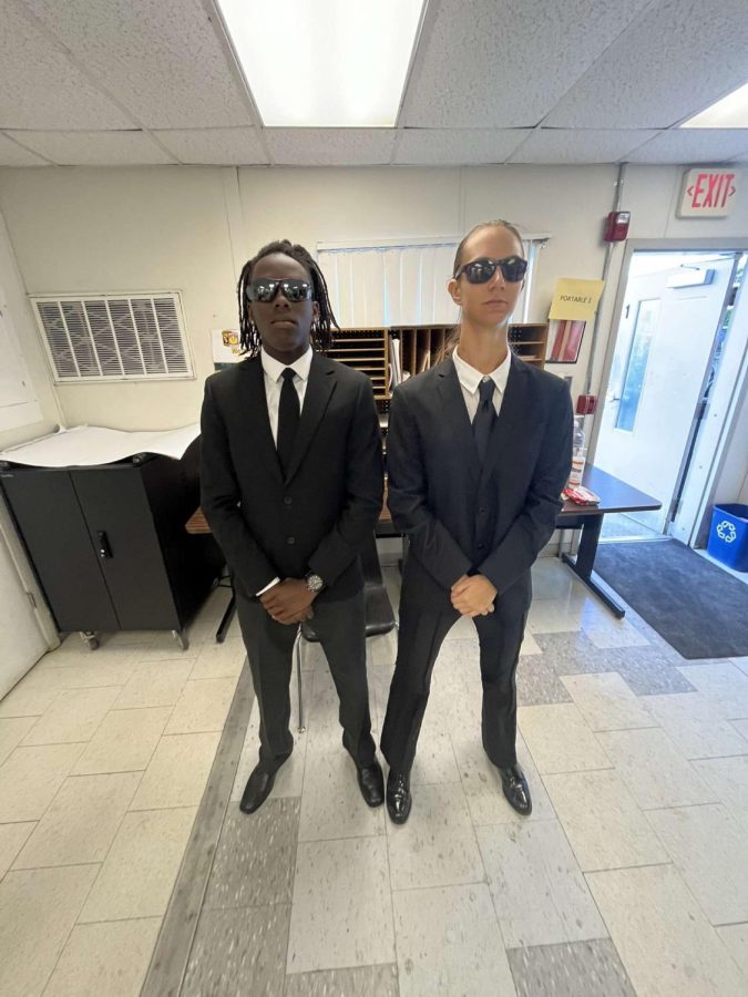 Seniors Kurt Reid Jr and Nichole Sassman (senior) dress as Men in Black at school on Oct. 31. 